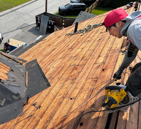 roofer removing asphalt shingles